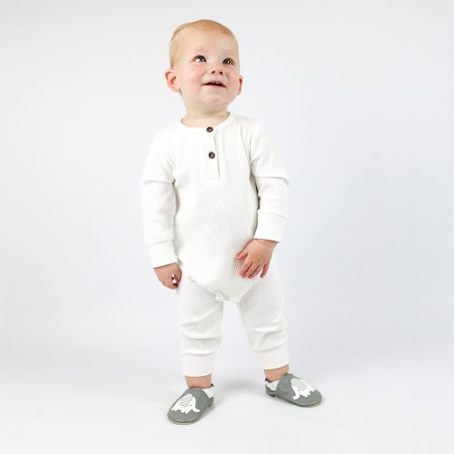 Infant boy standing, wearing grey Dotty Fish barefoot shoes with white and grey stripe elephant design.