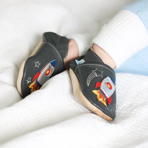 Baby boy wearing charcoal Dotty Fish shoes with silver space rocket design.