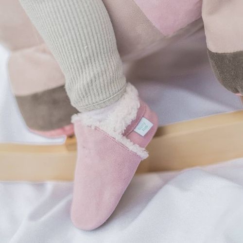 Small child wearing pale pink suede slippers from Dotty Fish.