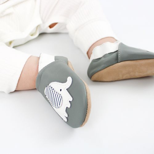 Toddler wearing grey leather Dotty Fish first walker shoes with white and grey stripe elephant design.