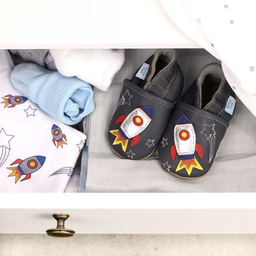 Baby shoes with rocket design, in drawer with baby clothing.