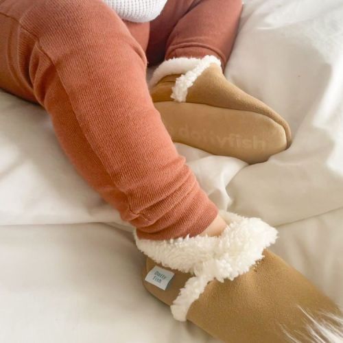 Toddler wearing tan suede slippers from Dotty Fish.