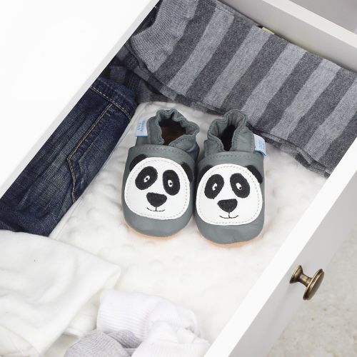 Grey leather shoes with panda design, in drawer with baby clothing.