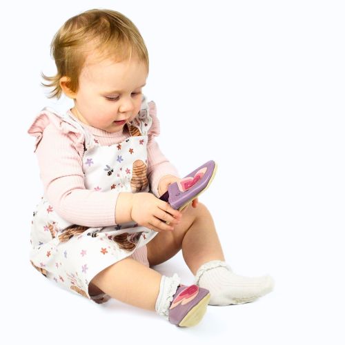 Baby girl wearing purple leather shoes with pink butterfly.