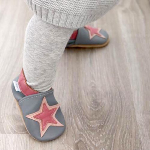 Toddler wearing grey leather shoes with pink star.