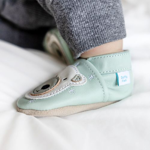 Toddler wearing light blue leather Dotty Fish first walker shoes with white polar bear design.