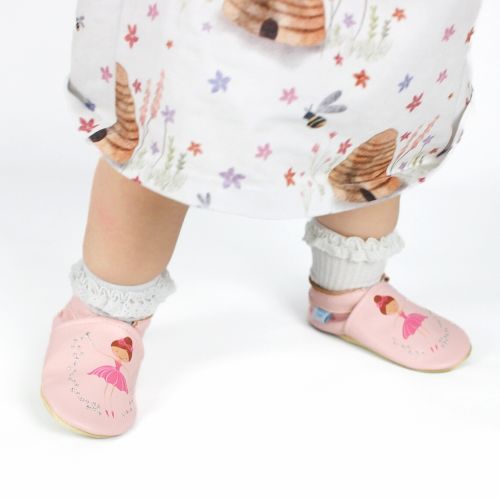 Toddler wearing pink leather ballerina shoes.