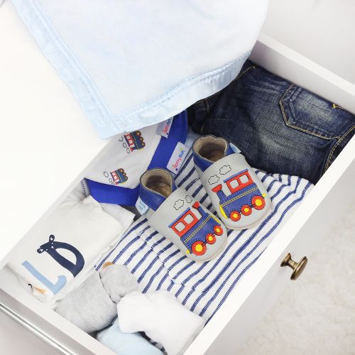 Grey train shoes, in drawer with baby clothing.