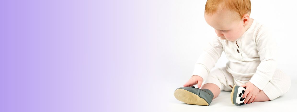 Small boy wearing Dotty Fish grey panda soft sole shoes