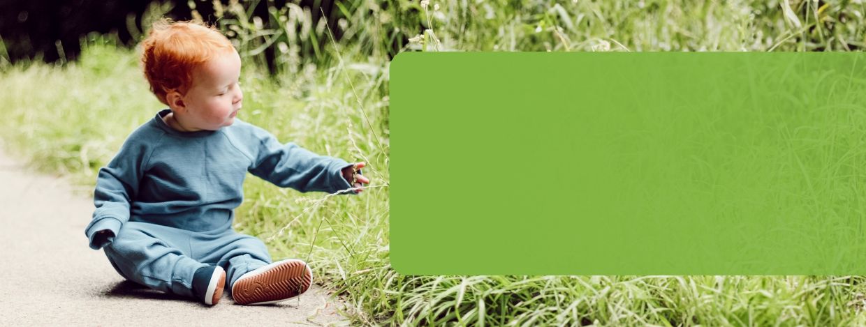 Small boy wearing Dotty Fish Navy Rubber Sole Slip-on Pre-walkers in a park