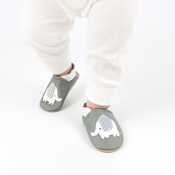 Toddler wearing grey leather Dotty Fish first walker shoes with white and grey stripe elephant design.