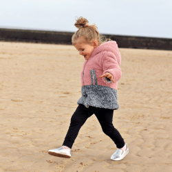 Little girl on beach wearing Dotty Fish silver leather pre-walker rubber sole slip-on shoes.