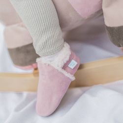 Small child wearing pale pink suede slippers from Dotty Fish.