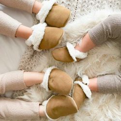 Three young children wearing Dotty Fish tan slippers.