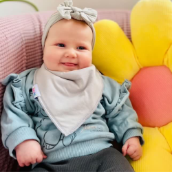 Baby girl wearing Dotty Fish pale grey cotton bandana bib.