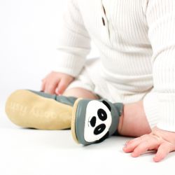 Toddler wearing grey leather shoes with panda design.