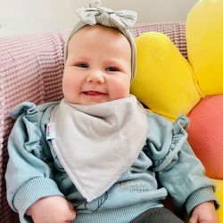 Baby girl wearing Dotty Fish pale grey cotton bandana bib.