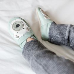 Toddler wearing light blue leather Dotty Fish first walker shoes with white polar bear design.