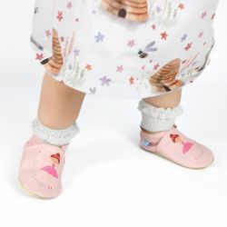 Toddler wearing pink leather shoes with ballerina design.