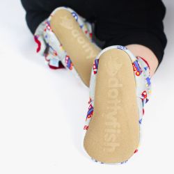 Toddler wearing grey cotton booties, showing the suede sole.