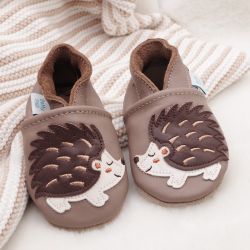 Light brown leather Dotty Fish soft sole pre-walker shoes with brown and cream hedgehog design, and cream stripe blanket.