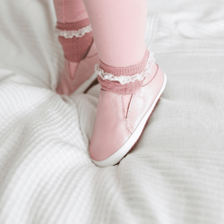 Little girl wearing Dotty Fish pink leather pre-walker rubber sole slip-on shoes.